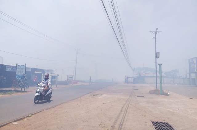 Ruas Jalan Buti di Merauke tertutup asap akibat kebakaran rumput kering di tanah lapang di Kelurahan Seringgu Jaya, Distrik Merauke, Kabupaten Merauke. (BumiPapua.com/Abdel Syah)