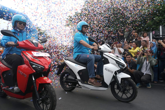 Gubernur DKI Jakarta Anies Baswedan (kanan) mengendarai sepeda motor  listrik saat Karnaval Jakarta Langit Biru di Patung Pemuda Membangun, Senayan, Jakarta. Foto: Iqbal Firdaus/kumparan 