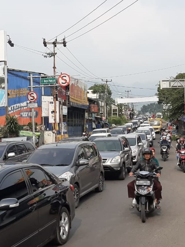 Kendaraan melaju seusai polisi mengembalikan sistem satu arah jalur puncak saat uji coba sistem kanalisasi 2:1 di Jalur Puncak, Bogor, Jawa Barat.  Foto: kumparan 