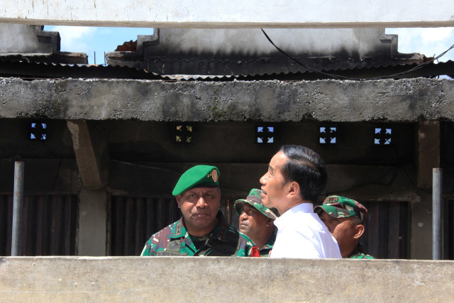 Presiden Joko Widodo (kedua kanan) mengamati bangunan yang terbakar saat kerusuhan lalu di Pasar Wouma, Kota Wamena, Kabupaten Jayawijaya, Papua, Senin (28/10). Foto: ANTARA FOTO/Anyong