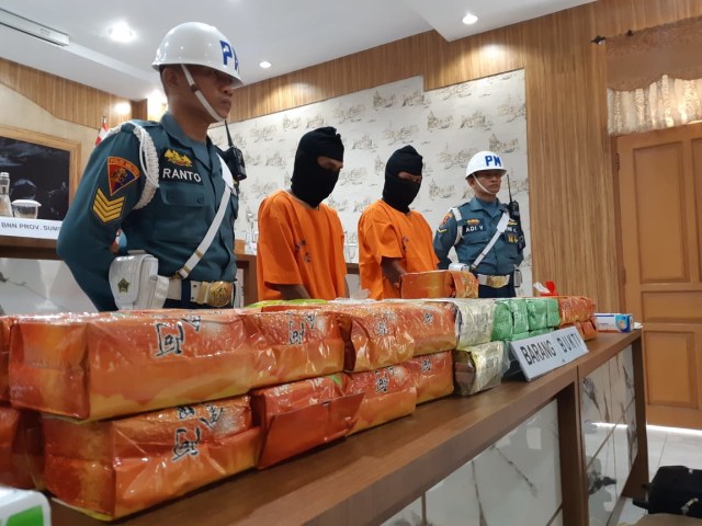 Kedua tersangka dan barang bukti 79 kg sabu diamankan di Lanal palembang. (foto: W. Pratama/Urban Id)