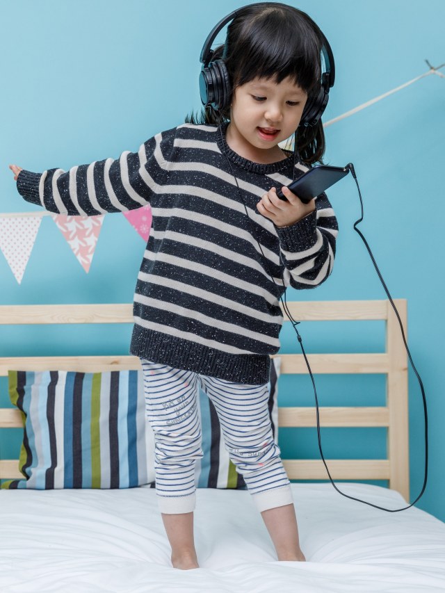 Anak pakai headphone untuk dengar musik. Foto: Shutter Stock 