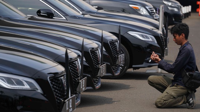 Seorang wartawan memotret sejumlah mobil dinas baru pimpinan DPR/MPR Toyota Crown 2.5 HV G-Executive yang terparkir di Gedung DPR, Jakarta, Selasa (29/10).  Foto: Irfan Adi Saputra/kumparan 