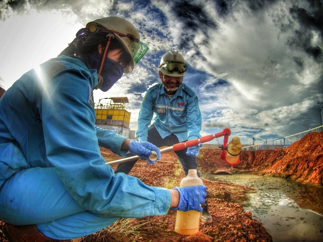 Karyawan PT Well Harvest Winning memonitor drainase dan outlet IPAL (Instalasi Pengolahan AirLimbah) di Smelter Grade Alumina (SGA) di Kecamatan Kendawangan, Kabupaten Ketapang, Kalimantan Barat. Foto: Suhandi Basri