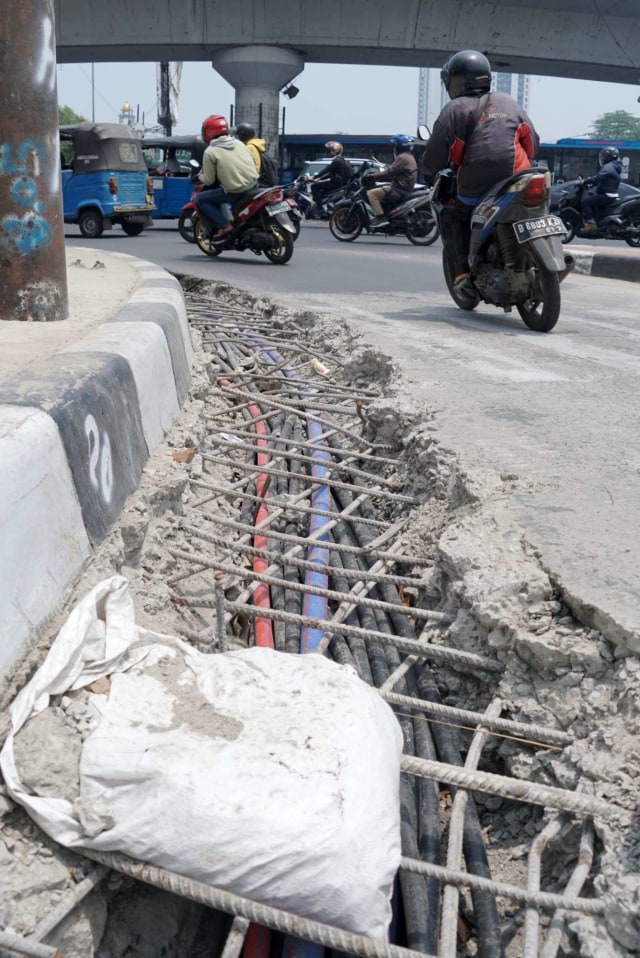 Sejumlah motor melintasi jalan di sebelah penataan kabel di Matraman, Jakarta Timur. Foto: Helmi Afandi Abdullah/kumparan