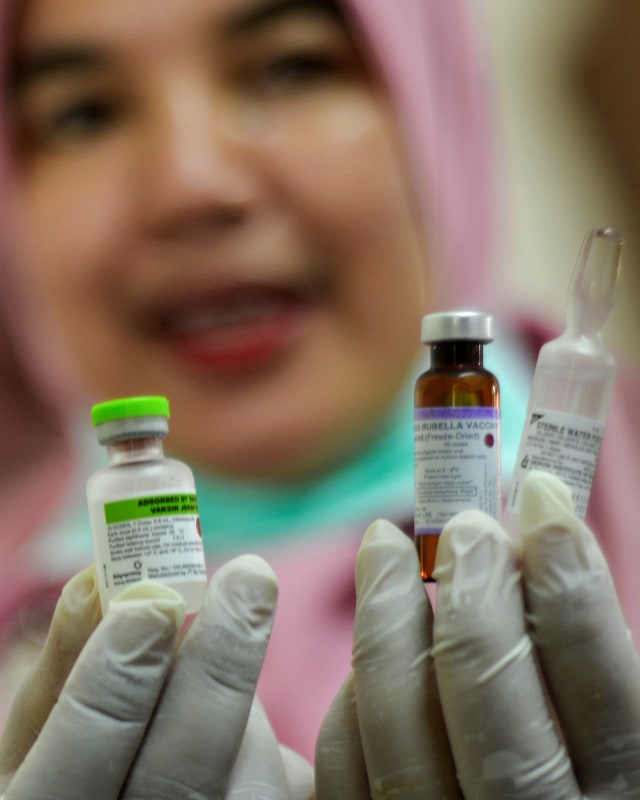 Perawat menunjukan suntikan dan vaksin difteri di salah satu sekolah di Banda Aceh, Selasa (29/10/2019). Foto: AFP/CHAIDEER MAHYUDDIN