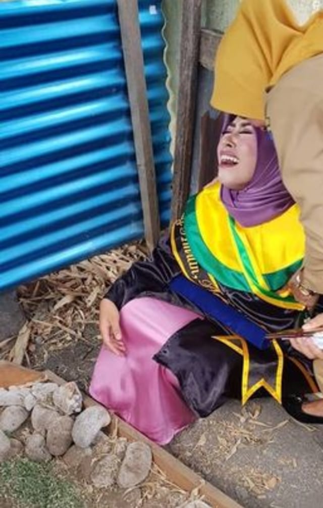 Seorang wisudawati menangis di makam ibunya selepas diwisuda. (Foto: Instagram @makassar_iinfo)