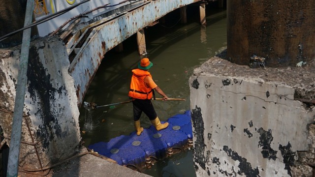 Petugas membersihkan sampah yang mengapung di aliran anak Kali Ciliwung, Pasar Baru, Kamis (29/8). Foto: Fanny Kusumawardhani/kumparan