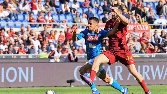 Pemain AS Roma dan Napoli berebut bola. Foto: Andreas SOLARO / AFP