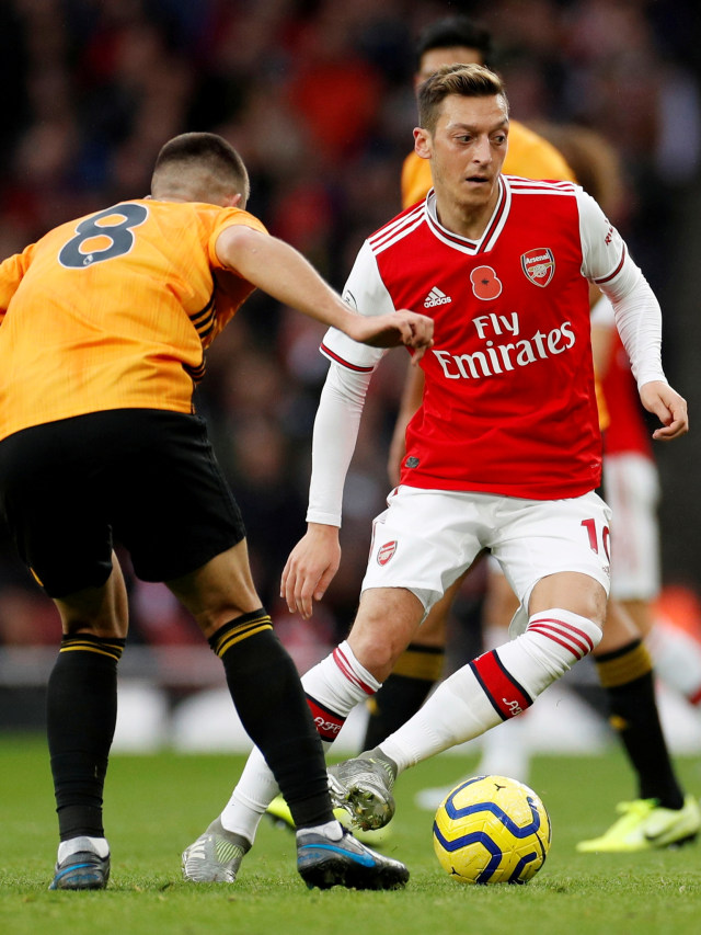 Pemain Arsenal Mesut Ozil (kanan) menggiring bola pada pertandingan Arsenal vs Wolverhampton Wanderers di Emirates Stadium, London, Inggris, Sabtu (2/11/2019). Foto: REUTERS/Eddie Keogh