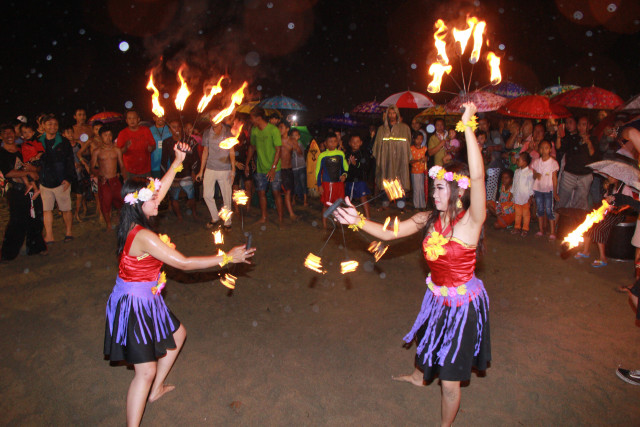 Para perempuan menari dengan membawakan api sebelum acara surfing di malam hari digelar, Sabtu malam (2/11). Foto: bayu eka novanta/tugumalang.id