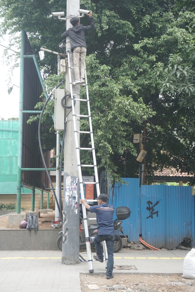 Petugas mengecek cctv di tiang listrik Kawasan Cikini, Jakarta.  Foto: Iqbal Firdaus/kumparan