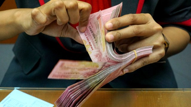 Pegawai menghitung uang rupiah di gerai penukaran uang Ayu Masagung di Jalan Kramat Kwitang, Senen, Jakarta Pusat, Kamis (7/11). Foto: Nugroho Sejati/kumparan