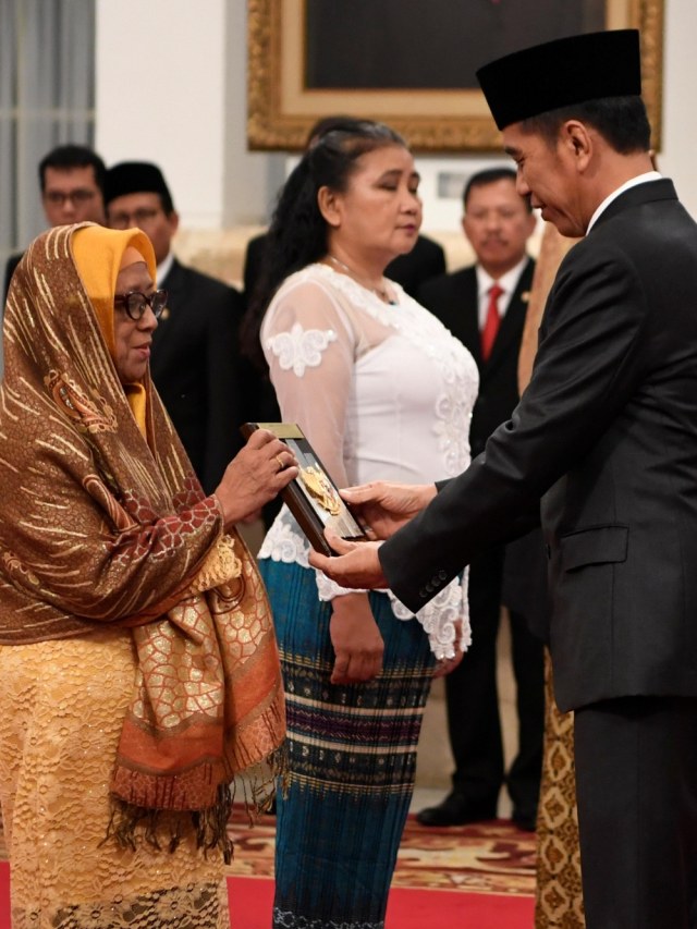 Presiden Joko Widodo (kanan) menyerahkan plakat anugerah gelar pahlawan nasional kepada ahli waris Prof KH Abdul Kahar Mudzakkir di Istana Negara, Jakarta. Foto: ANTARA FOTO/Puspa Perwitasari