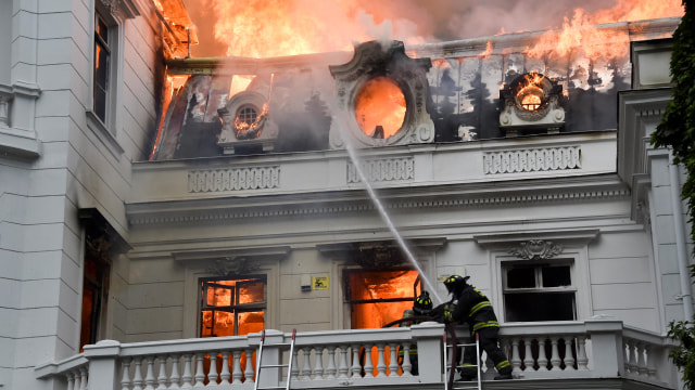 Petugas pemadam kebakaran memadamkan api di Universitas Pedro de Valdivia setelah protes terhadap pemerintah di Santiago, Chile, Jumat (8/11). Foto: AFP/RODRIGO ARANGUA