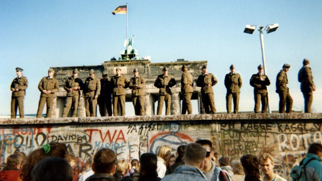 Sejumlah tentara berdiri di atas Tembok Berlin pada 11 November 1989. Foto: AFP/GUNTHER KERN