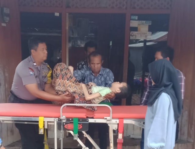 Aiptu Hasan Virdiez saat mengevakuasi Inun(21) dijalan Bengaris VII, Tanjung Pinang, Palangka Raya,  Minggu 10 November 2019.(Foto: Arnoldus) 