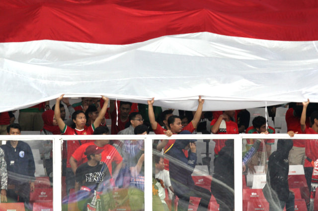 Suporter Indonesia membentangkan bendera saat melawan Korea Utara di Kualifikasi Piala Asia U-19 di Stadion Utama GBK, Jakarta, Minggu (10/11/2019).
 Foto: Nugroho Sejati/kumparan