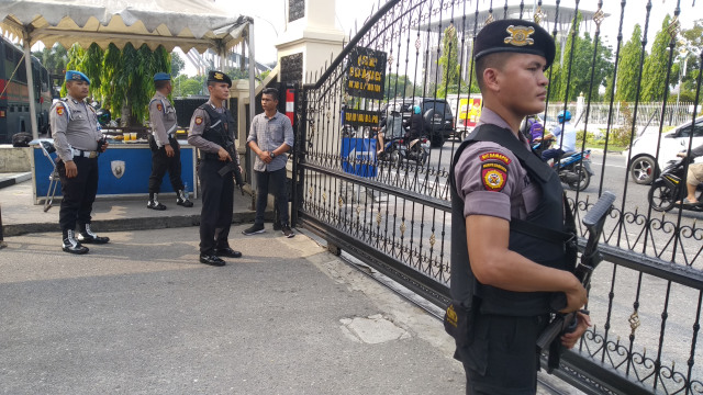 ANGGOTA Polisi bersenjata laras panjang dan pistol bersiap di pintu gerbang masuk Mapolda Riau, Rabu, 13 November 2019. Pengamanan ditingkatkan usai penyerangan disertai bom bunuh diri di Mapolrestabes Medan, Sumatera Utara. 