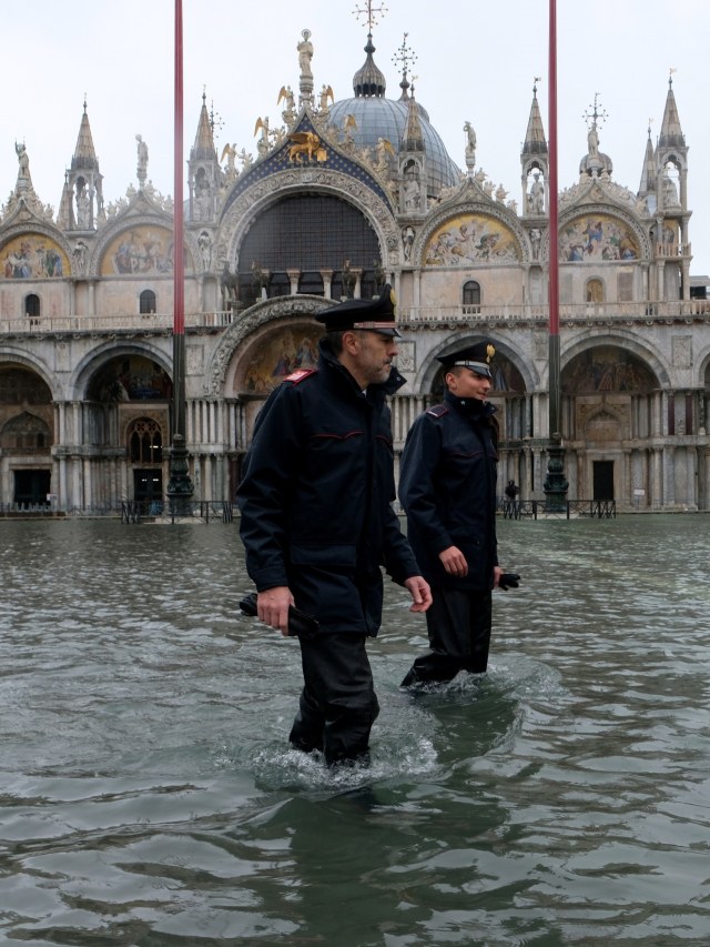 Polisi berpatroli saat St.Mark's Square terendam banjir di Venesia, Italia. Foto: REUTERS / Manuel Silvestri