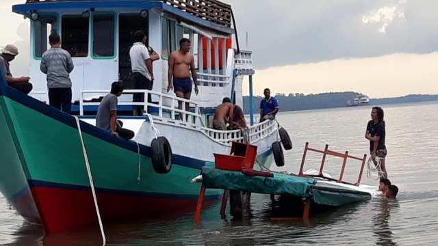 Proses evakuasi penumpang perahu wisata Rimba Princess ke perahu nelayan di Sungai Kumai. (Foto: KSOP Kumai)