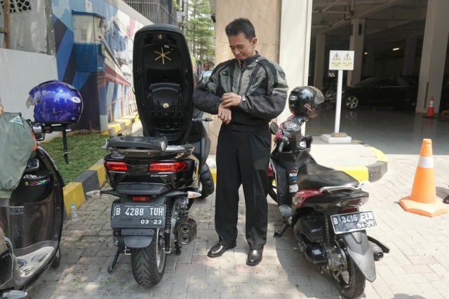 Chandra Hamzah bersiap mengenakan jaket sebelum meninggalkan kementerian BUMN dengan sepeda motornya. Foto: Iqbal Firdaus/kumparan