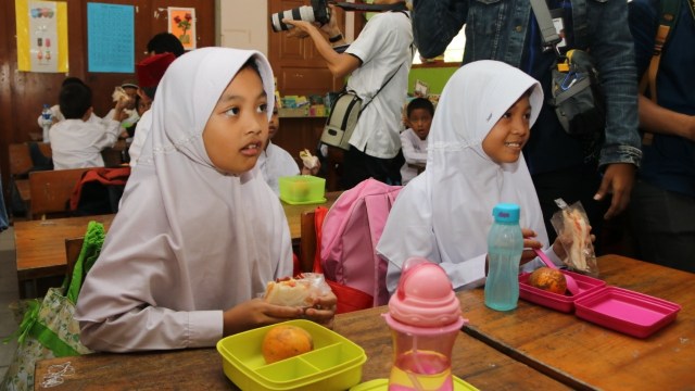 Sejumlah siswa sekolah dasar mengikuti program Pemberian Makanan Tambahan Anak Sekolah (PMTAS) oleh Gubernur DKI Jakarta Anies Baswedan. Foto: Dok. Pemprov DKI