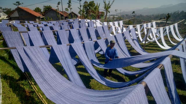 Perajin menjemur kain untuk dijadikan kain pel di sentra industri tradisional Kampung Babakan, Desa Dukuh, Kecamatan Ibun, Kabupaten Bandung, Jawa Barat. Foto: ANTARA FOTO/Raisan Al Farisi