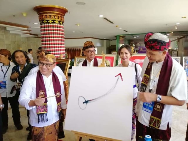 AAGN Ari Dwipayana (kiri) saat bersama Ketua Umum KAGAMA Ganjar Pranowo menorehkan garis untuk dijadikan lukisan serangkaian pameran lukisan di arena Munas XIII KAGAMA (IST)