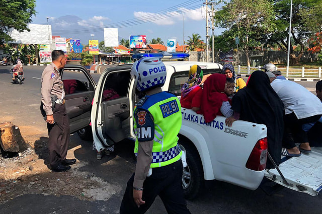 Petugas dengan menggunakan mobil bak terbuka mengangkut sejumlah warga yang terlantar akibat aksi demo ratusan sopir angkot di Kabupaten Kuningan, Selasa (19/11/2019). (Andri Yanto)