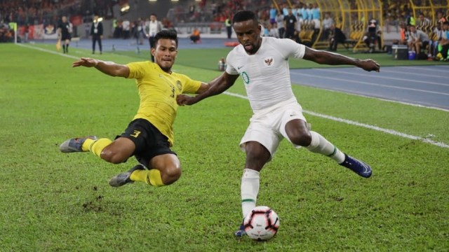 Pemain Timnas Indonesia Greg Nwokolo (kanan) berusaha melewati pemain Timnas Malaysia di Stadion Bukit Jalil, Malaysia. Foto: Jamal Ramadhan/kumparan 