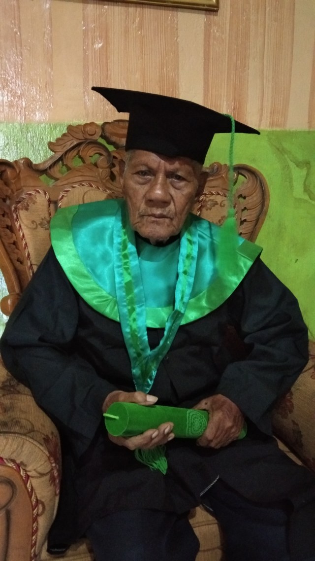 La Ode Muhammad Sidik mengenakan toga di ruang tamu rumahnya yang beralamat di Kelurahan Wameo, Kecamatan Batupoaro, Kota Baubau. Foto: Rusman/kendarinesia.