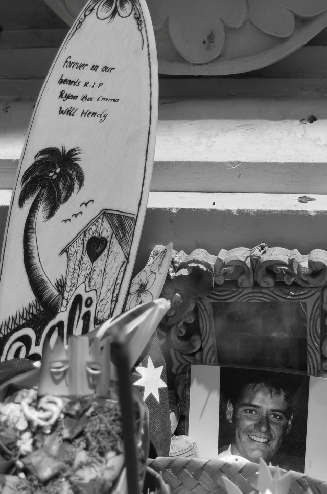 Papan selancar ditempatkan di samping foto korban tewas tragedi Bom Bali. Foto: Antara Foto/Fikri Yusuf