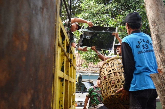 Anggota TNI Kodim 0615 Kuningan bersama warga gotong royong membersihkan sampah yang mengotori sejumlah titik di Kecamatan Garawangi. (Andri Yanto)