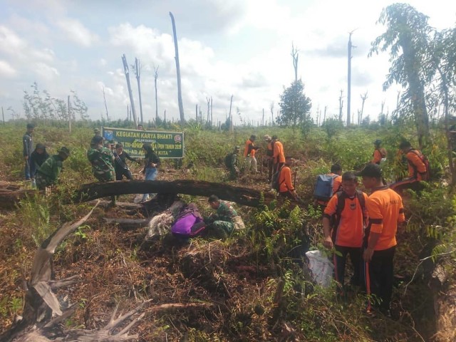 TNI bersama relawan melakukan penanaman pohon di area lahna bekas kebakaran. (Foto: Kodim 1014/Pbn)