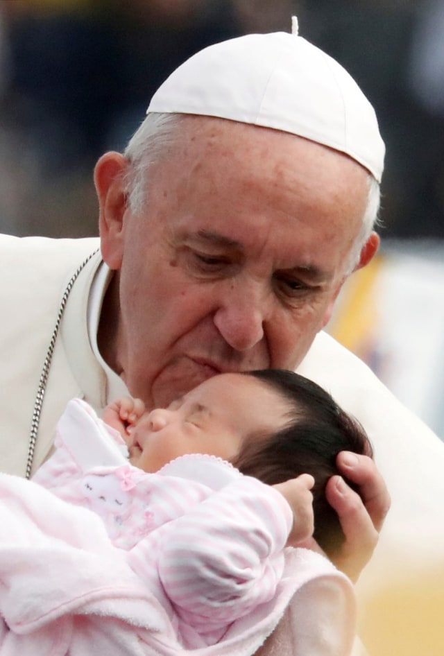 Paus Fransiskus mencium kening seorang bayi saat kunjungan ke Nagasaki, Jepang. Foto: Reuters