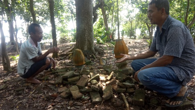 ISMAIL (kiri) saat berbincang-bincang dengan warga menjelaskan sejarah keberadaan makam tua ratusan tahun di Desa Pangkalan Batang, Pulau Bengkalis. 