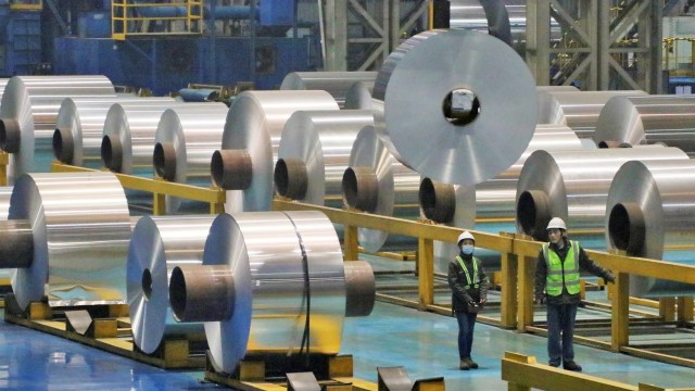 Dua orang pekerja di jalur produksi gulungan aluminium. Foto: REUTER / Stringer