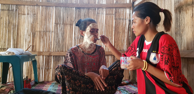 Erista, anak sulung Mama Maria, mendampingi ibunya yang kesulitan makan akibat sakit tumor yang dideritanya. Foto: Florespedia.