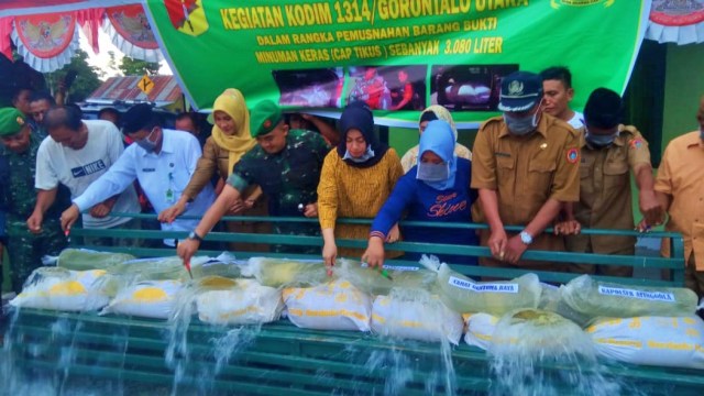 Dandim 1314 Gorontalo Utara, Letkol ARM Firstya Andrean Gitrias, bersama pejabat daerah saat melakukan pemusnahan miras. (25/11). Foto : Dok Banthayo.id