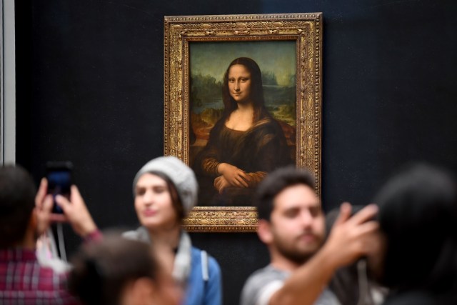 Wisatawan berfoto di depan lukisan Mona Lisa di Paris. Foto: AFP/ERIC FEFERBERG