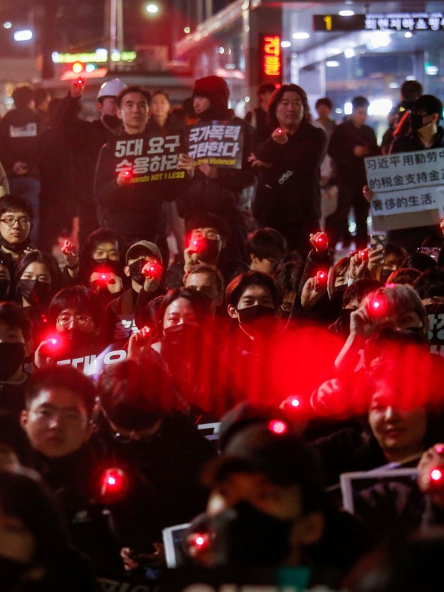 Para siswa membawa laser saat demonstrasi untuk mendukung pengunjuk rasa pro-demokrasi Hong Kong di Seoul, Korea Selatan. Foto: REUTERS/Heo Ran