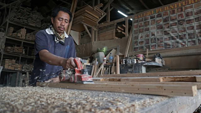 Seorang pekerja sedang memotong kayu di Industri Mebel Jatinegara Kaum, Jakarta TImur, Rabu (27/11). Foto: Iqbal Firdaus/kumparan