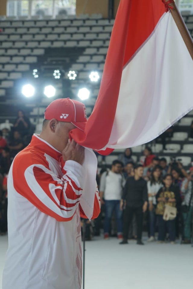 Atlet Indonesia mencium bendera merah putih saat pengukuhan kontingen Indonesia untuk SEA Games 2019 di Hall Basket GBK, Rabu (27/11/2019). Foto: Helmi Afandi Abdullah/kumparan 