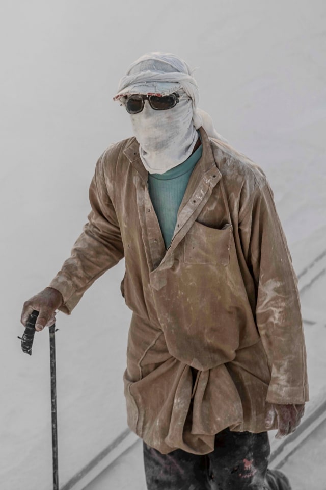 Pekerja mengenakan penutup wajah di lokasi tambang batu kapur "Gunung Putih" di dekat kota Selatan Mesir, Minya, Mesir. Foto: AFP/KHALED DESOUKI
