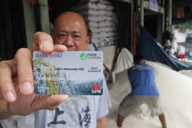 Seorang pedagang menunjukkan kartu pedagang di Pasar Induk Beras Cipinang, Jakarta. Foto: Dok. Bank DKI 