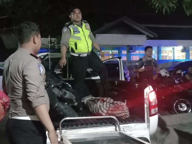 FOTO Salah satu petugas kepolisian Polresta Palangka Raya saat hendak mengangkat jenazah korban dari mobil ke ruang jenazah, Jumat 29 November 2019.jpg