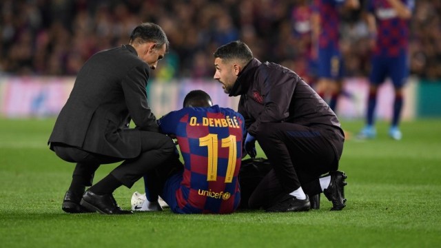 Ousmane Dembele terduduk kesakitan setelah mengalami cedera ketika membela Barcelona di laga versus Borussia Dortmund.  Foto: Josep LAGO / AFP