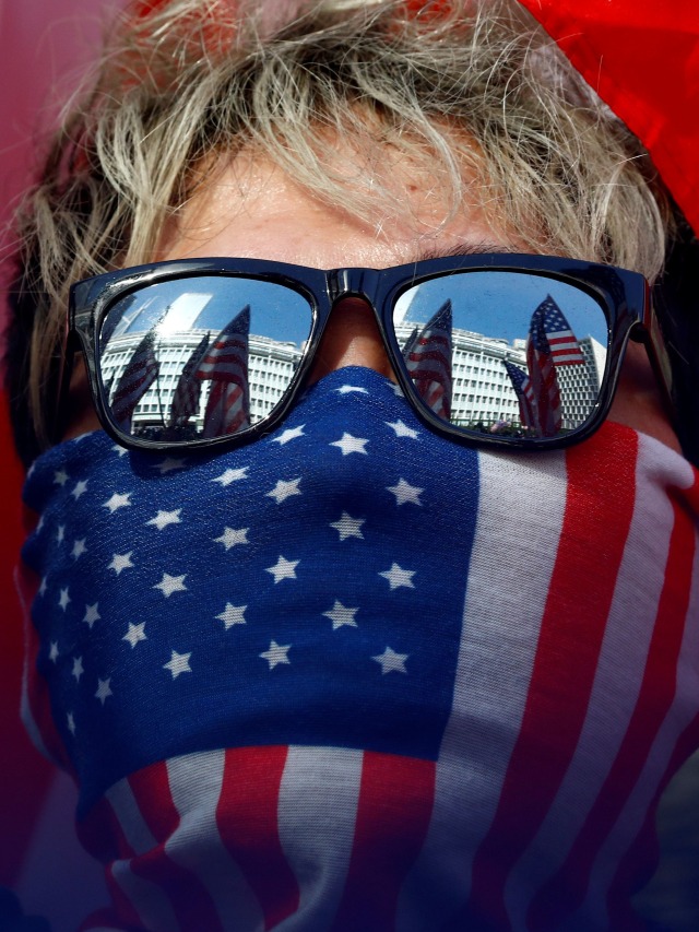 Pendemo menggunakan masker bergambar bendera Amerika saat aksi "March of Gratitude to US" di dekat Konsulat AS di Hong Kong, China. Foto: REUTERS/Thomas Peter