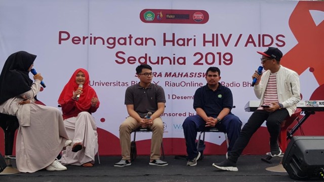 AKTIVIS pendamping Orang dengan HIV/AIDS (ODHA) dari Yayasan Sebaya Lancang Kuning, Hestin Setyawati (jilbab merah), saat menjelaskan HIV dan AIDS kepada warga Pekanbaru di Area Car Free Day, Minggu, 1 Desember 2019.